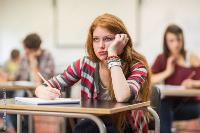 A bored college student looking up from classroom desk