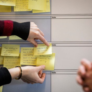 person putting sticky notes on a board