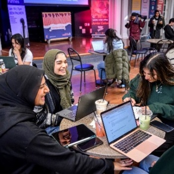 A group of students sitting around a table with laptops