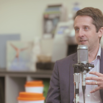 Makela speaking to microphone