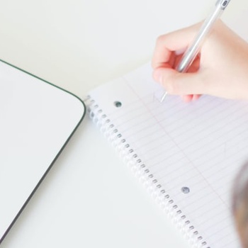 someone-taking-notes-with-their-weekly-planner-off-to-the-side