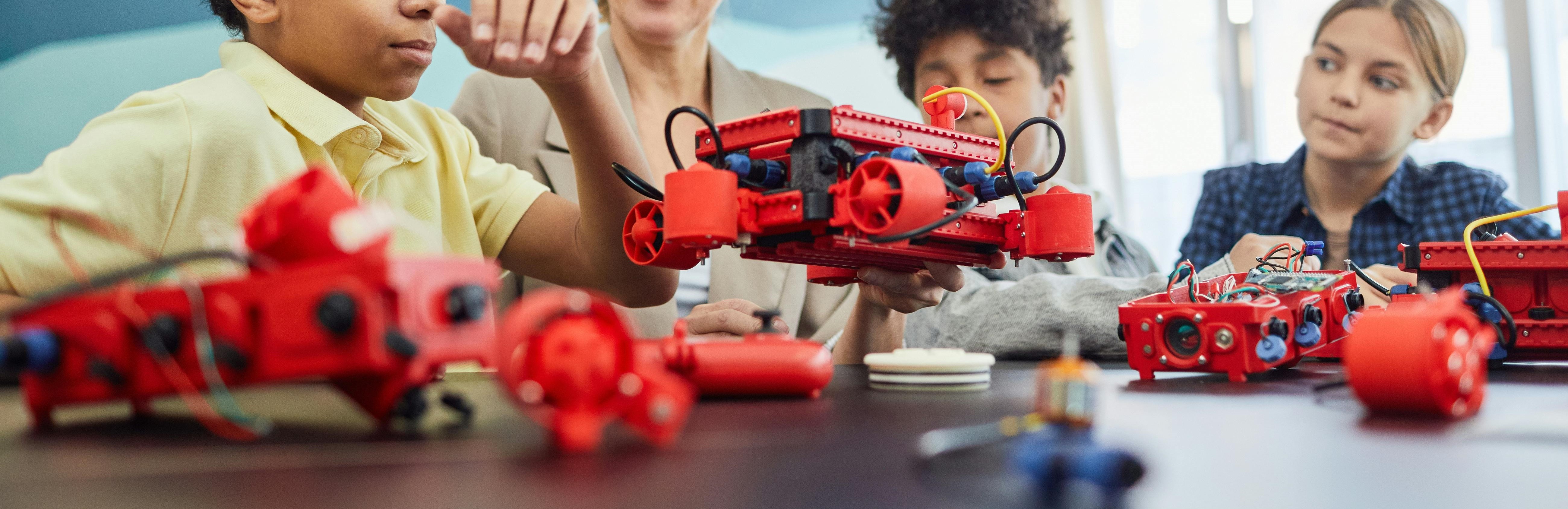 3 kids learning robotics with instructor